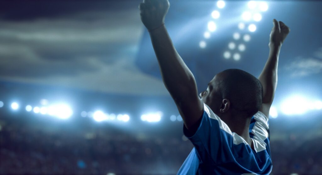 Football player celebrating with raised hands