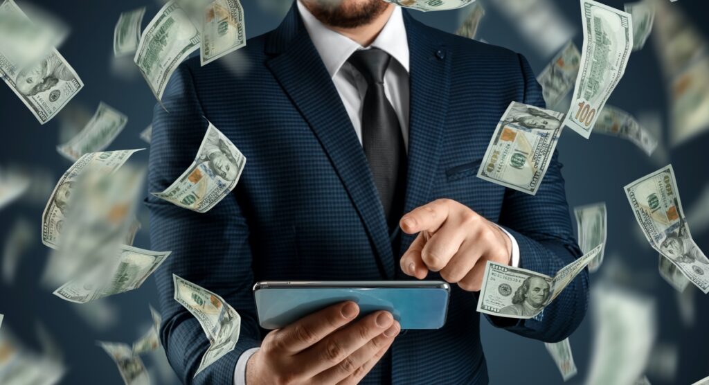 $100 bills flying around man using smartphone $100 bills flying around man using smartphone