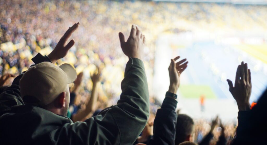 Supporters clapping hands inside stadium