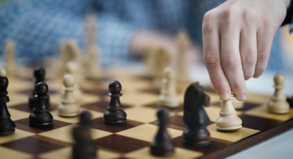 Player moving game piece during chess match