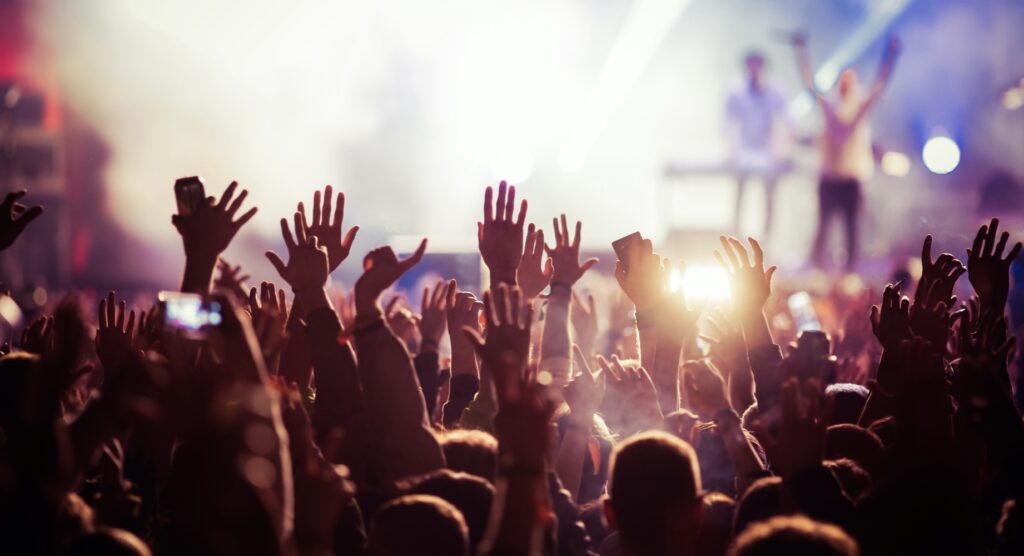 People in crowd raising their hands during concert