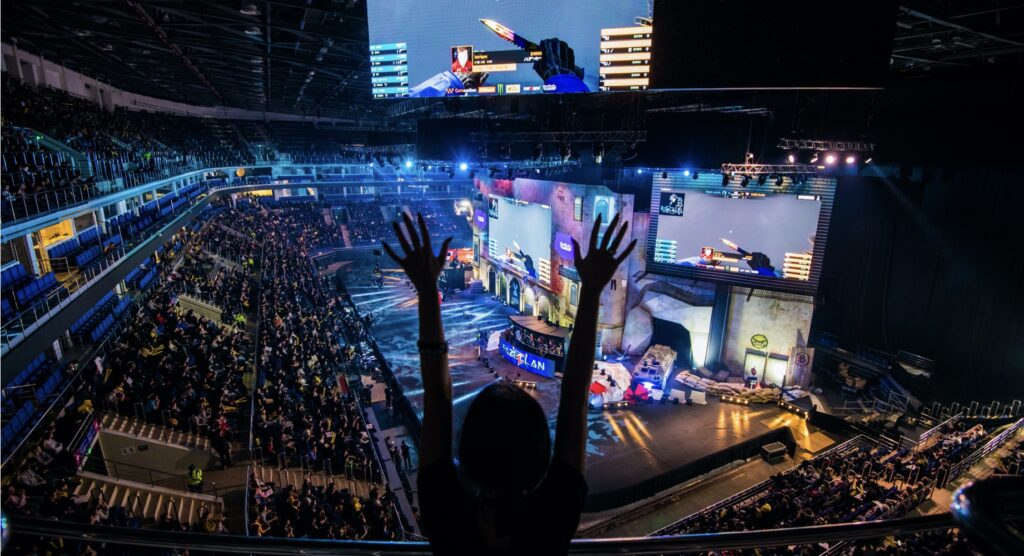 Female fan with hands raised celebrating at esports event