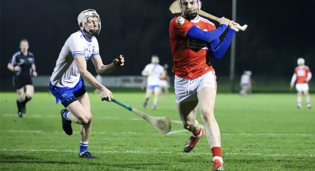 Two male hurling players during a match
