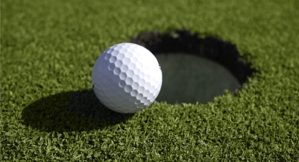Golf ball on edge of hole