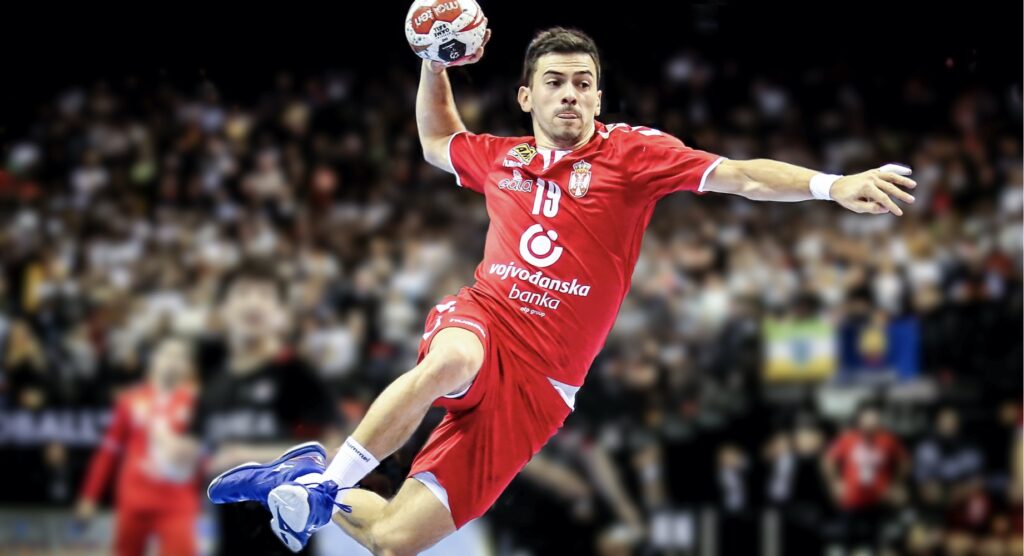 Handball player taking a shot while jumping in the air