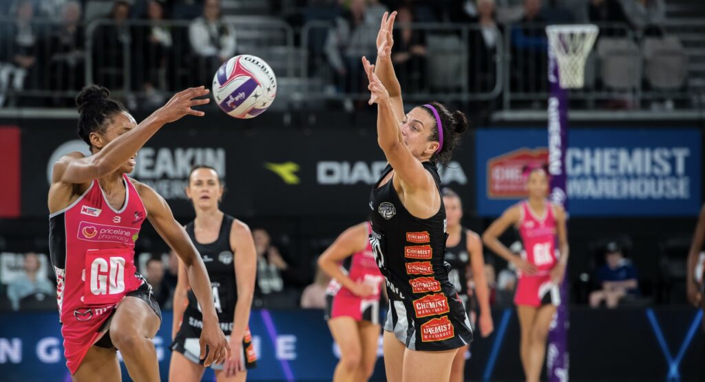 Player trying to make a block during a women's netball match Player trying to make a block during a women's netball match