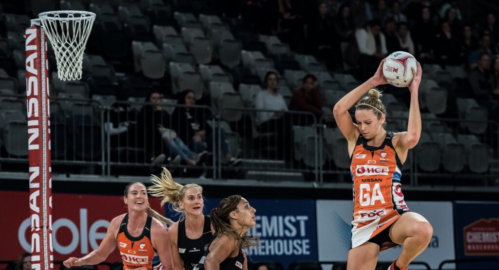 Player in mid-air after catching netball Player in mid-air after catching netball