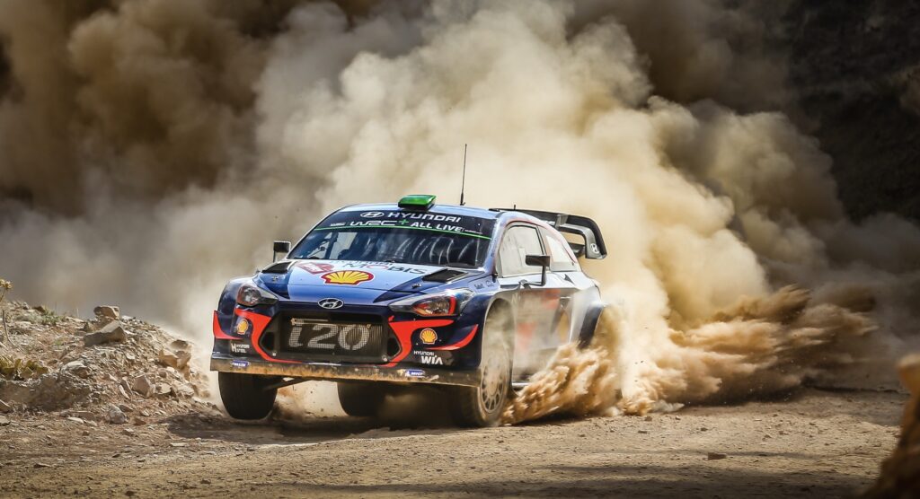 Car accelerating on a dirt track during World Rally Championship