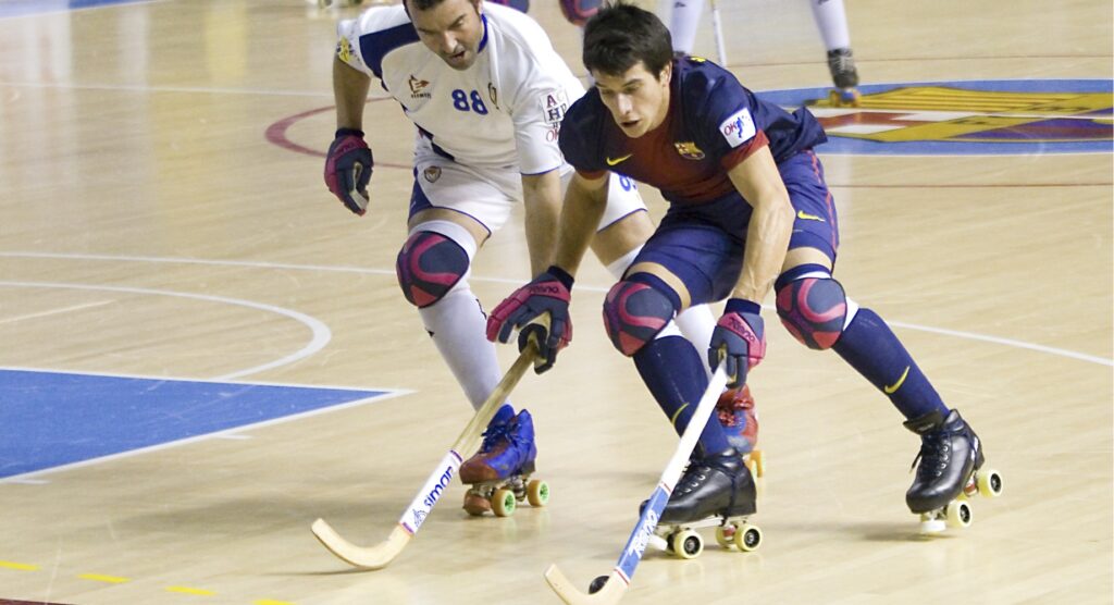 Rink hockey player controlling the ball while opponent tries to gain possession of it