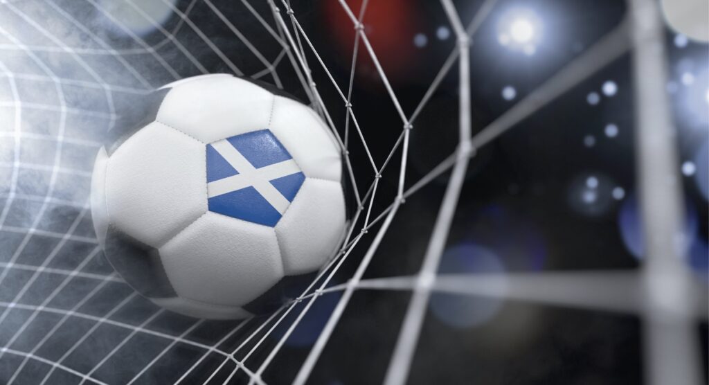 Football with flag of Scotland hitting back of net