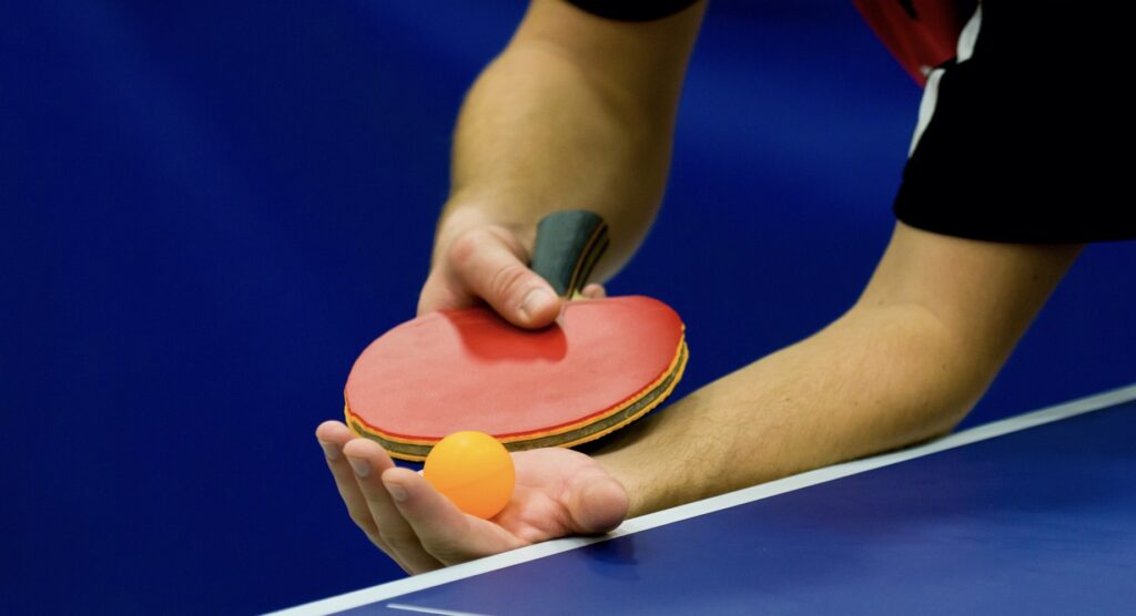 Close-up of player serving during table tennis match