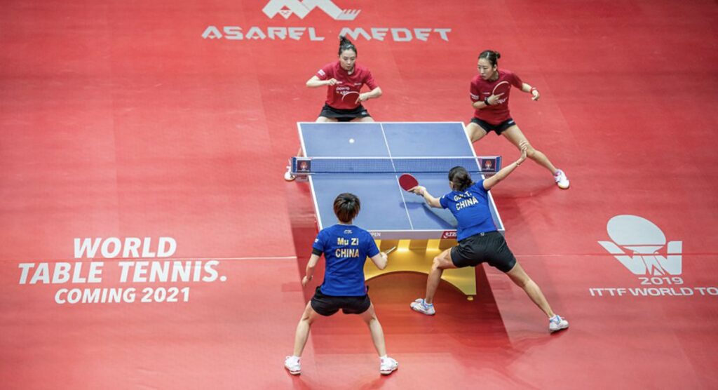 Table tennis players competing during women's doubles match