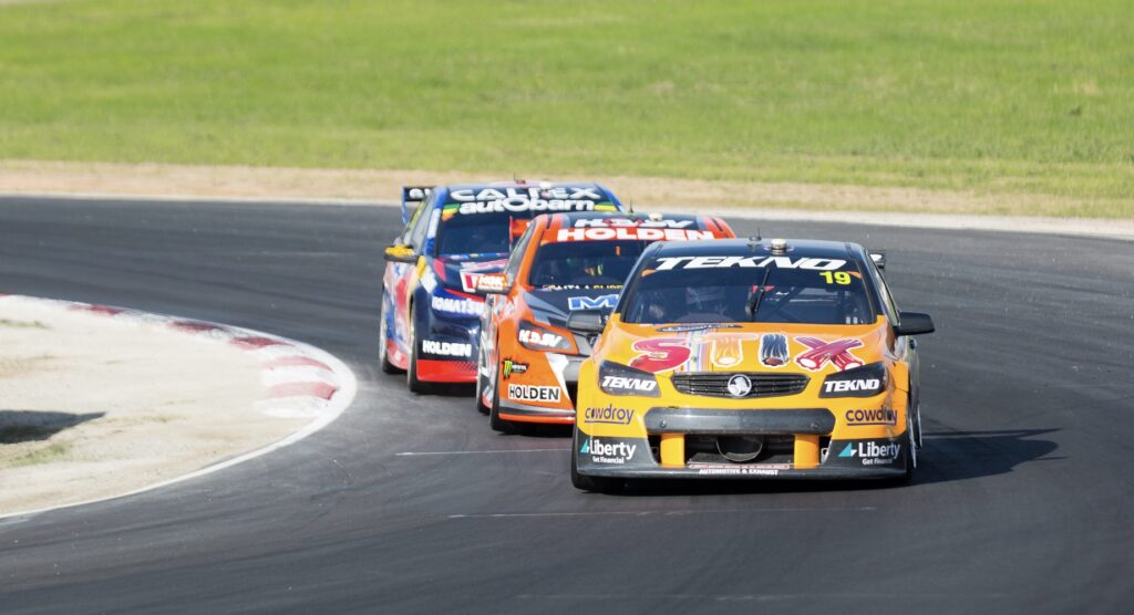 Three V8 Supercars racing around a bend