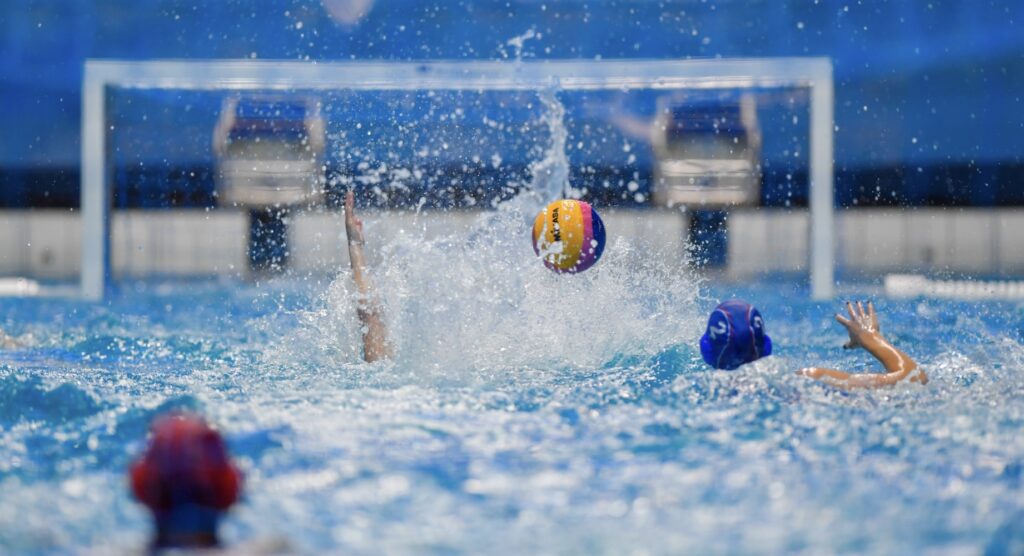 Players competing for ball during water polo match