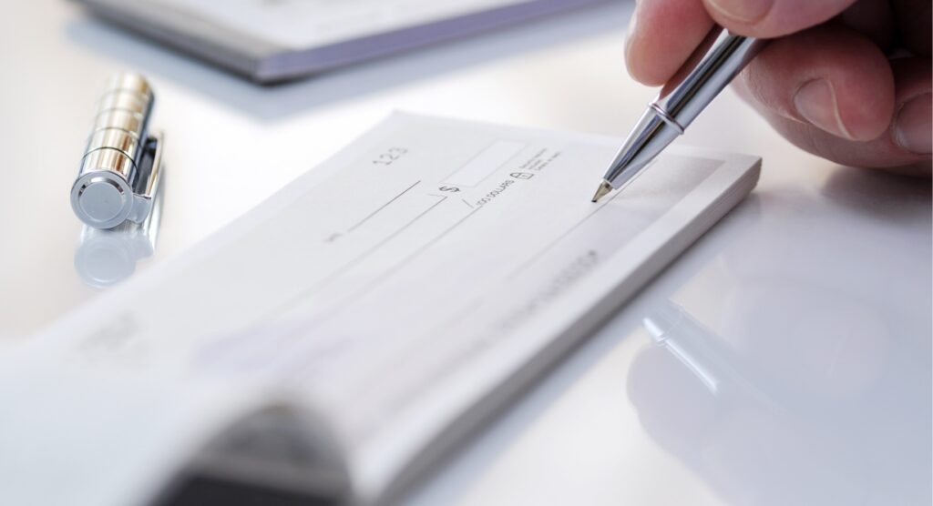 Man writing cheque on white table