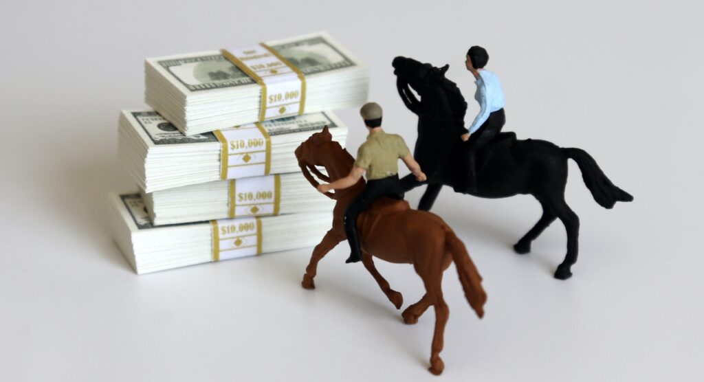 Miniature horses beside four bundles of cash