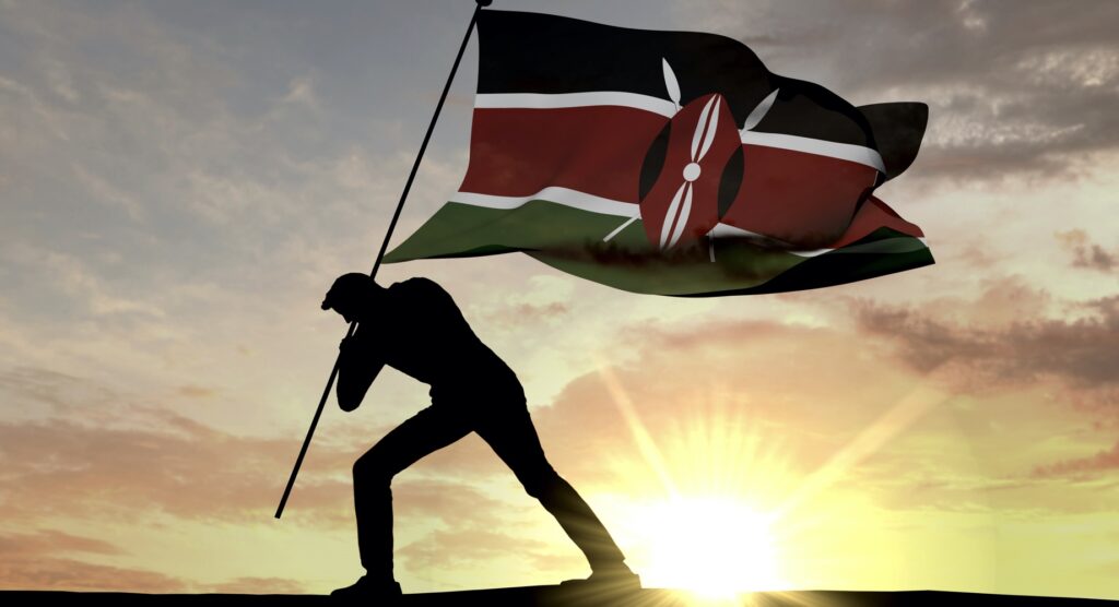 Man waving flag of Kenya against the sunset