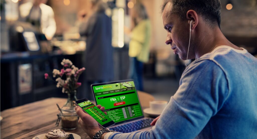 Male betting on laptop and smartphone