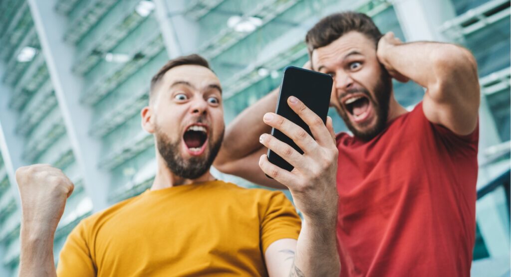 Two male friends celebrating winning bet