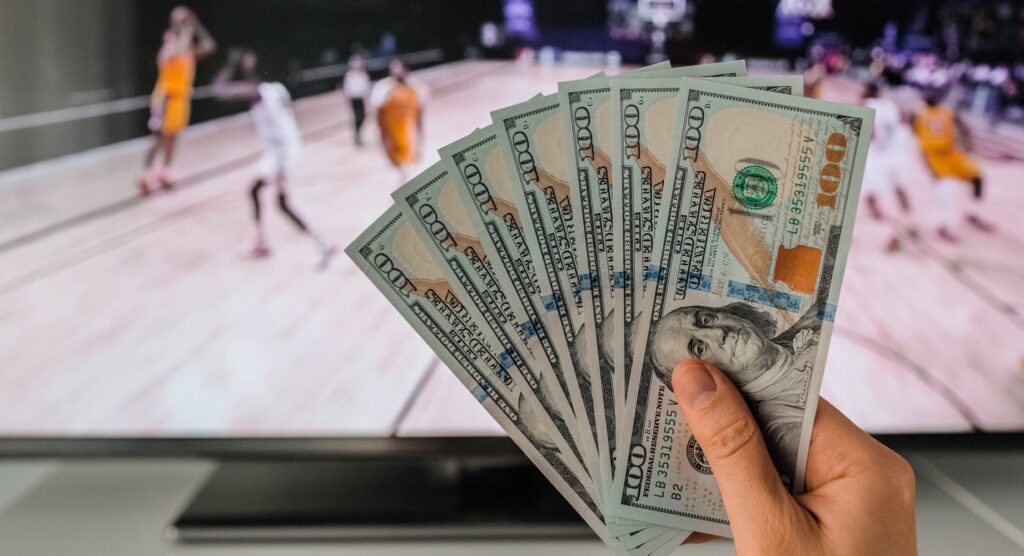 Man watching basketball with seven $100 bills