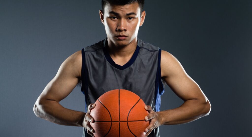 Asian basketball player holding ball