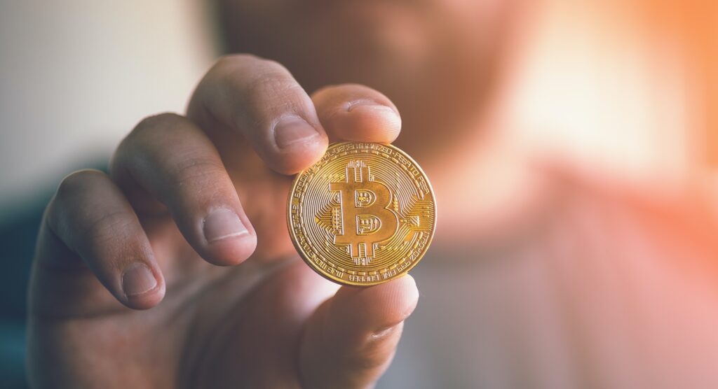 Man holding bitcoin-style coin Man holding bitcoin-style coin