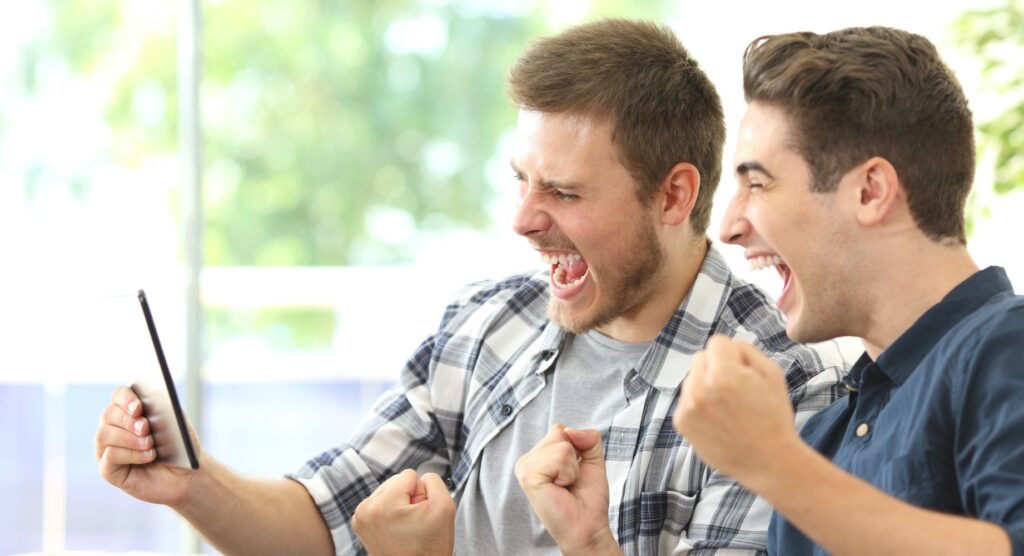 Two male friends celebrating winning bet