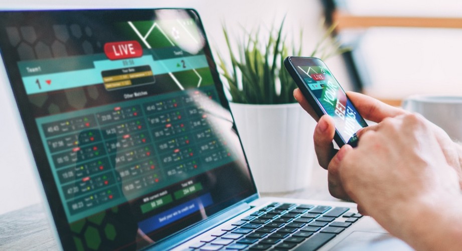 Man checking bet on laptop and smartphone