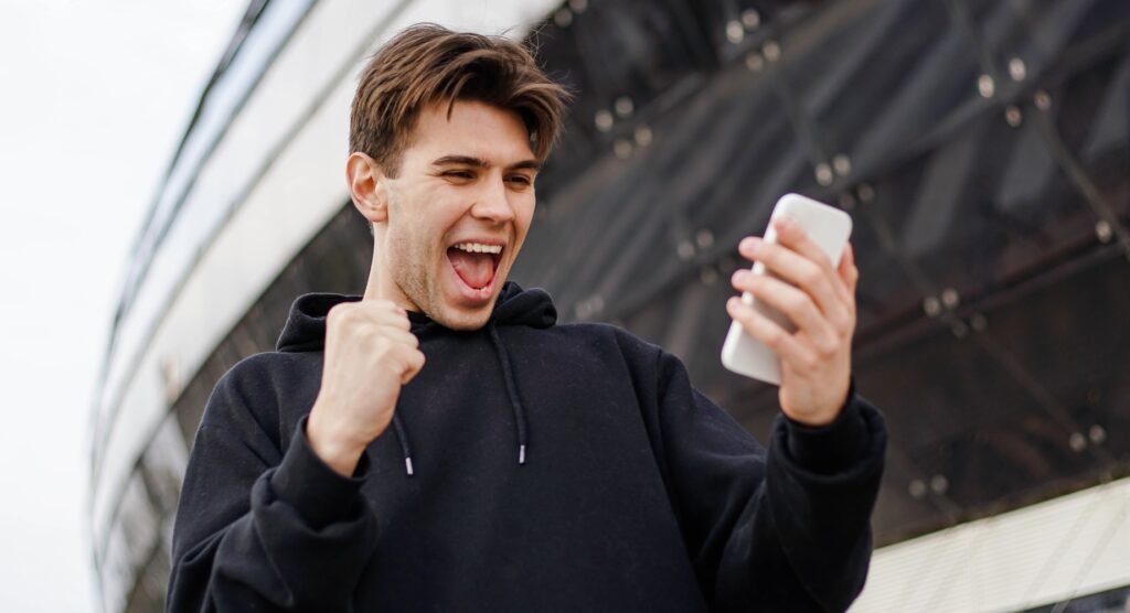 Man celebrating winning mobile bet