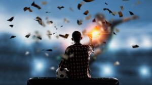 A man watching football on a screen and cheering as it rains money.