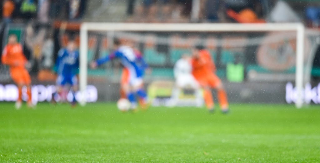 Grass on the football pitch with match in the background