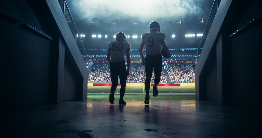 NFL players during scrimmage Diverse Professional American Football Players Running Out of the Stadium Tunnel