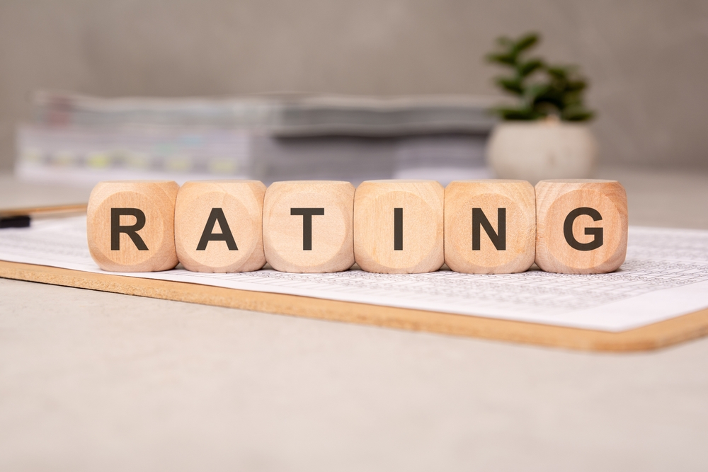 Wooden blocks spelling the word RATING on a clipboard Wooden letter blocks spelling RATING resting on a clipboard on a desk