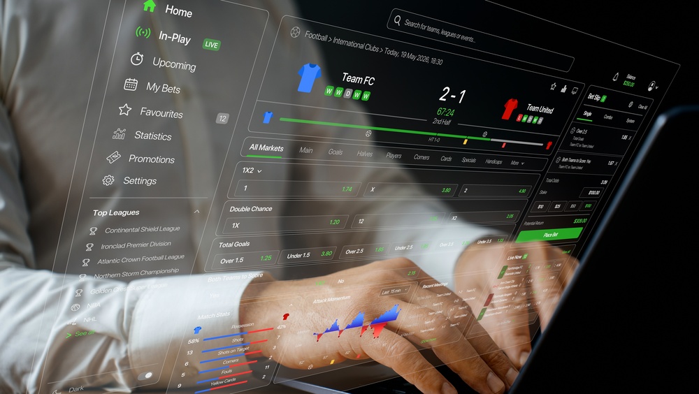 Online sportsbook interface showing live football betting markets Hands typing on a laptop with a sports betting interface overlaid showing live football odds and markets
