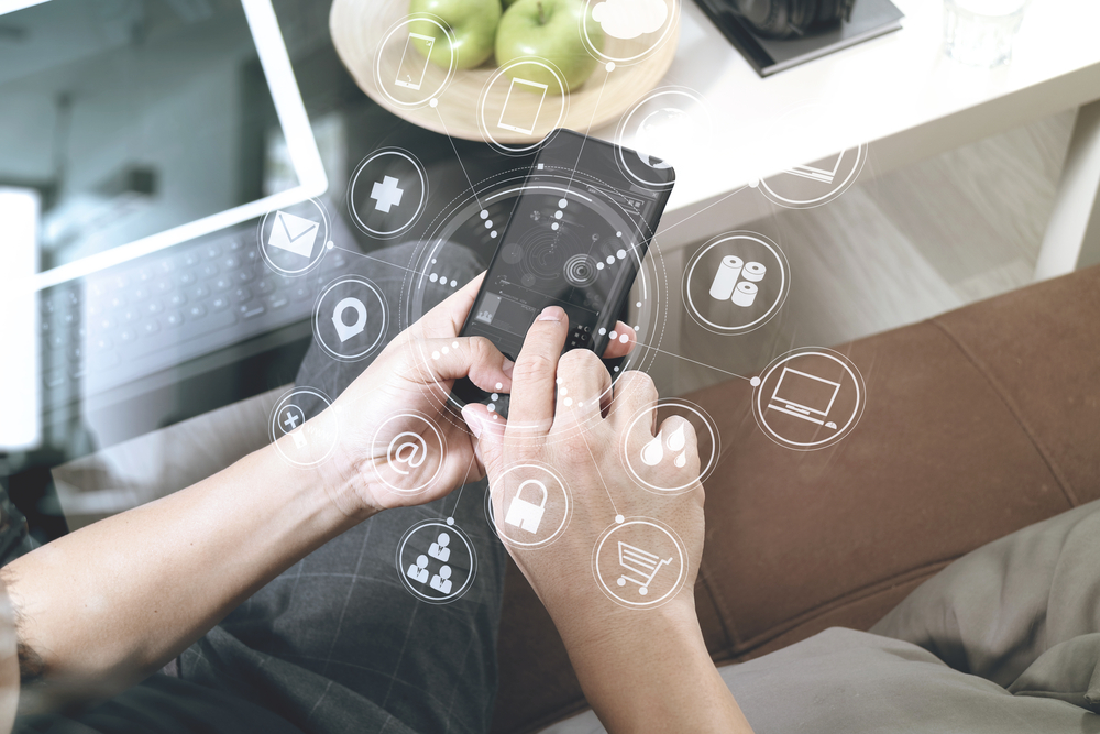 Smartphone use with digital connectivity icons Person using a smartphone with digital technology icons overlaid