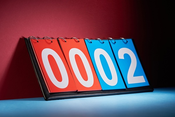 $100 bill and pencil on bet slip A blue and red score counter shows nil-two